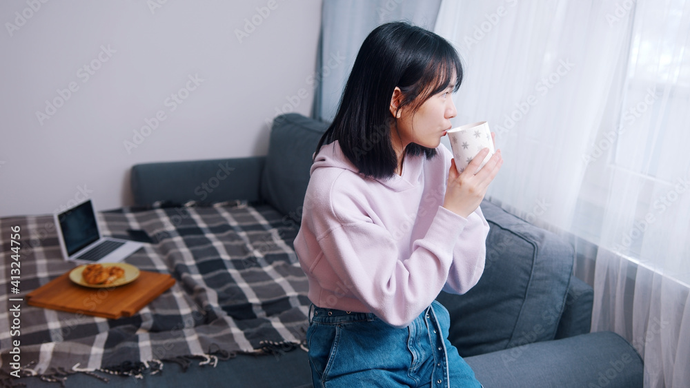 Young lonely asian woman drinking morning coffee and looking through the window. High quality photo Young lonely asian woman drinking morning coffee and looking through the window. High quality photo