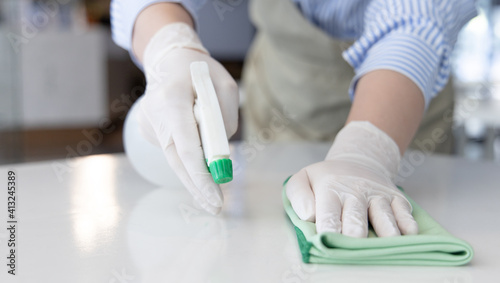 Close up Staff hand Restaurant workers are cleaning table and spraying disinfectants during the virus outbreak, Using cleaning solutions or using alcohol to kill germs in the restaurant.