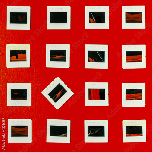 A square made up of four rows of old photographic slides on a red background photo