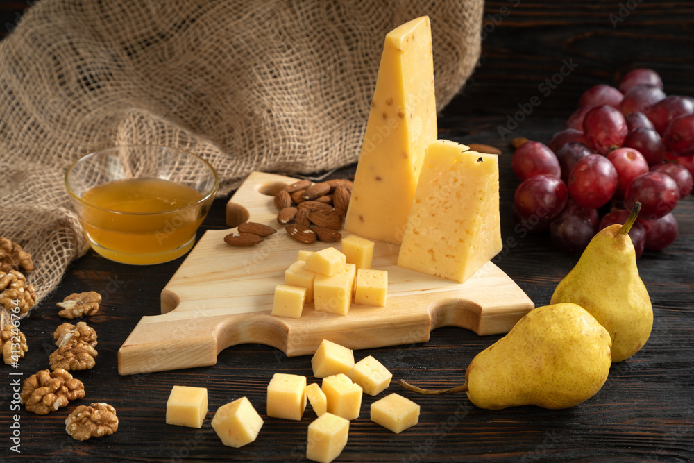 Cheese, pears and nuts on a wooden cutting board