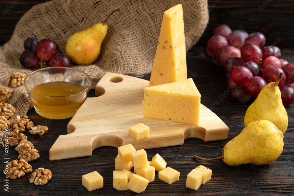 Cheese, pears and nuts on a wooden cutting board