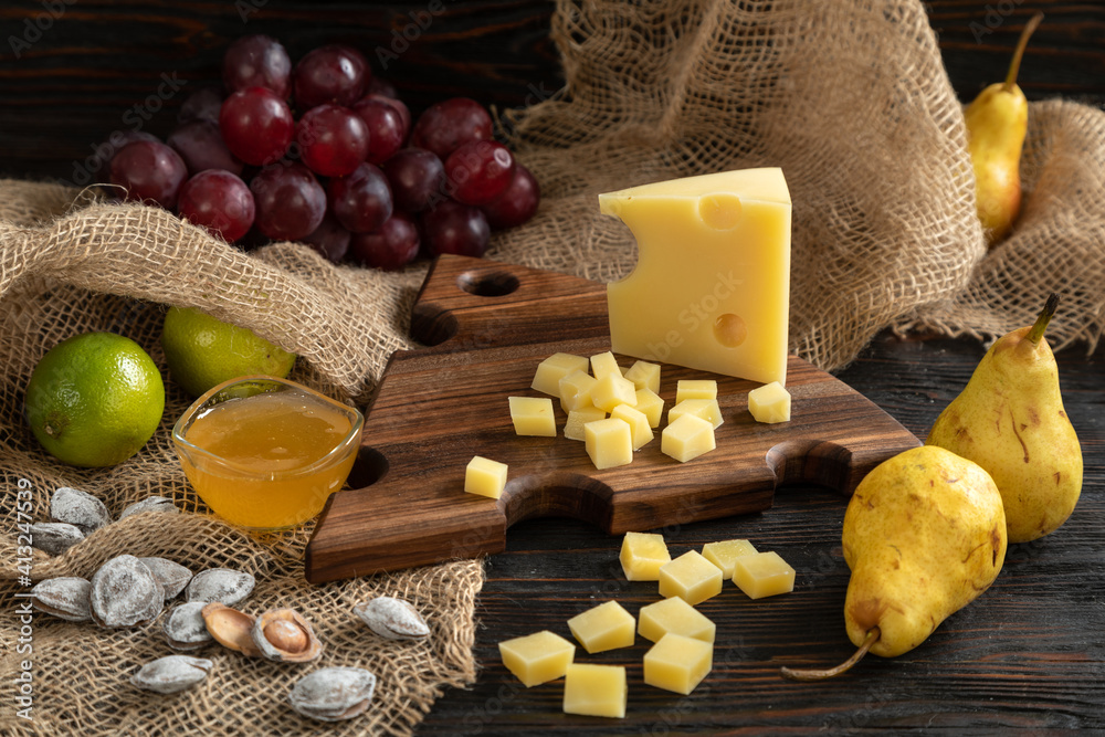 Cheese, pears and nuts on a wooden cutting board