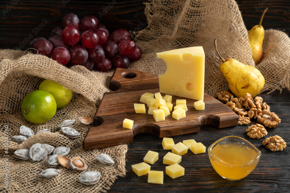 Cheese, pears and nuts on a wooden cutting board