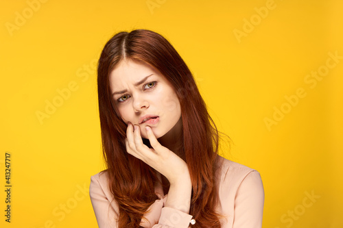 attractive woman holding hand near face charm emotion yellow background