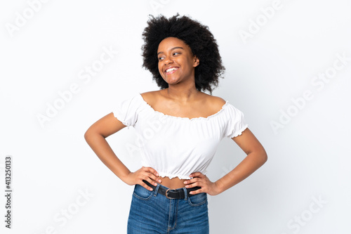 Young African American woman isolated on white background posing with arms at hip and smiling