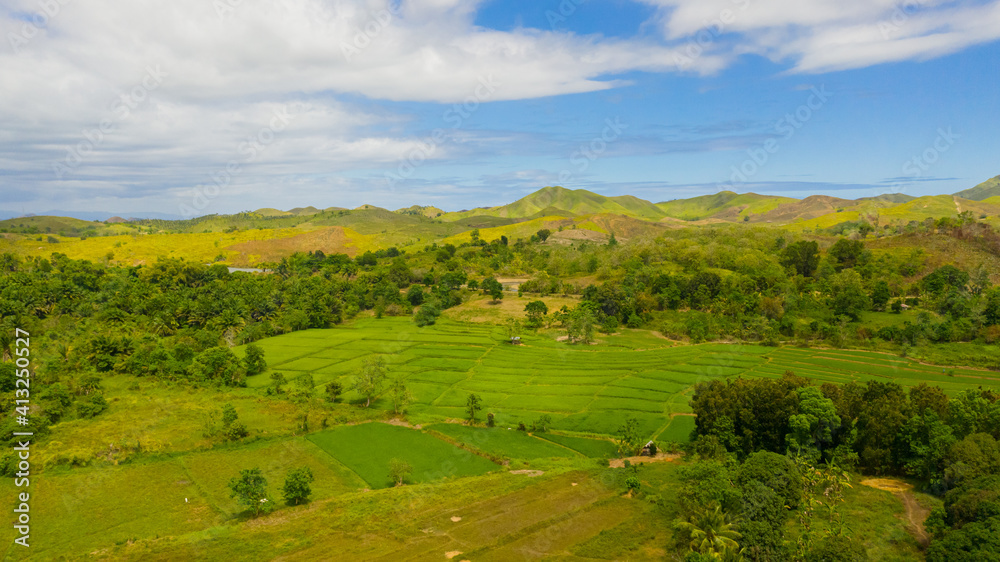 Hills and mountains covered with green grass against a background of blue sky and clouds. Bohol, Philippines. Summer landscape.