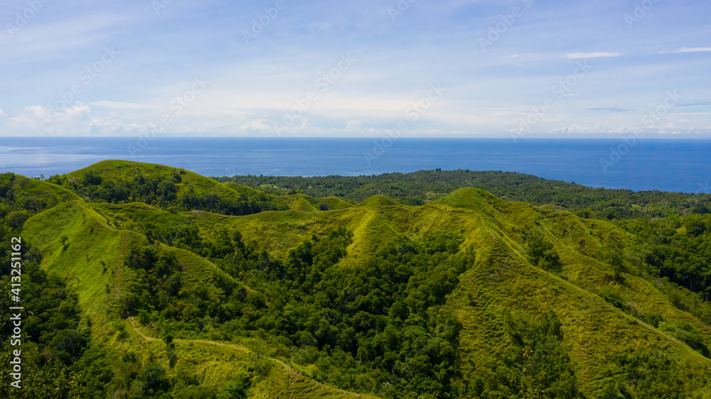 Summer tropical landscape. Green hills and mountains with tropical vegetation and blue sky with clouds. Bohol, Philippines.