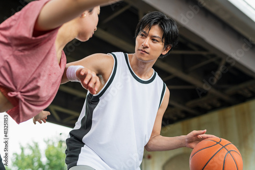バスケットボールをする男女 © One