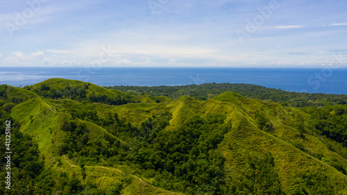 Fototapeta Naklejka Na Ścianę i Meble -  Summer tropical landscape. Green hills and mountains with tropical vegetation and blue sky with clouds. Bohol, Philippines.