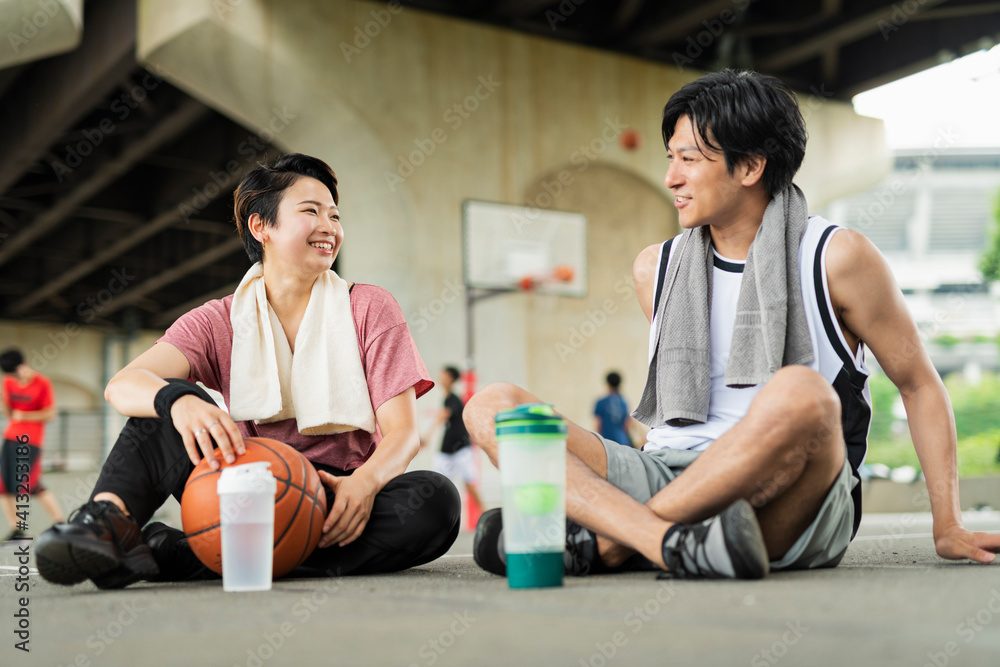 バスケの練習中に休憩をとる男女 バスケの練習中に休憩をとる男女
