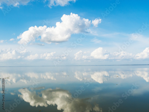 Brilliant blue sky and clouds relect on Lake Apopka at Winter Garden Florida © Photoman