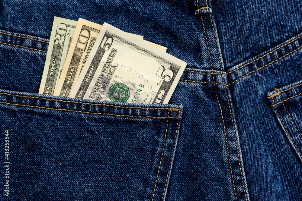 American dollars in jeans pocket background. Cash, money is in the pocket of blue jeans. Close-up American dollars in jeans pocket background. Cash, money is in the pocket of blue jeans. Close-up