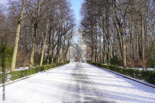Tor, Straße und Baumallee des Sowjetischen Ehrenmals im Treptower Park in Berlin im Winter bei Sonnenschein