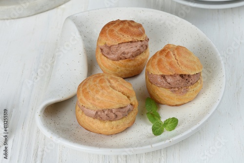 Choux pastry or Cream puffs filled chocolate custard.white background