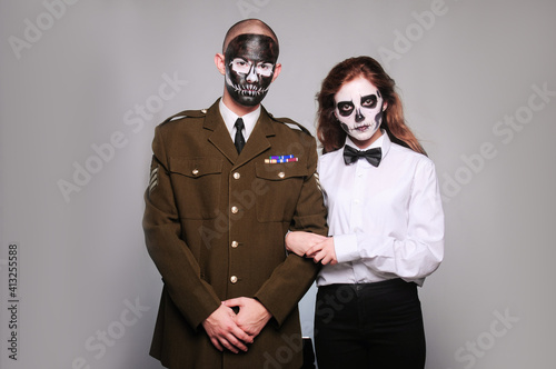 a girl and a man in Halloween makeup in the image of dead people with a black skull, dressed in military uniforms and a white shirt