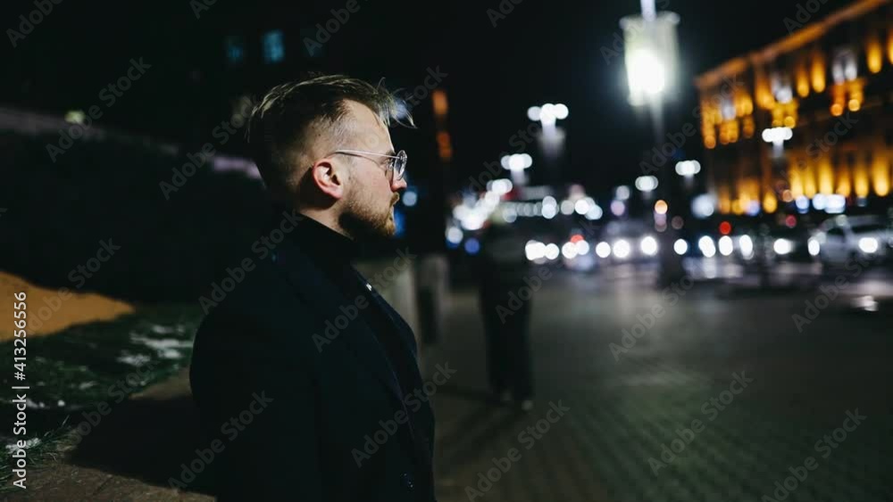 Lonely man in the city in the evening expects a woman on a date in winter Lonely man in the city in the evening expects a woman on a date in winter