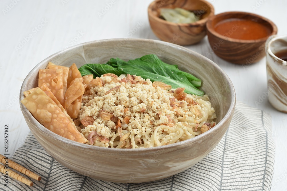 Cwie Mie is authentic noodles dish from Malang, Indonesia. Noodle served with minced chicken, fried shallot and fried dumpling or cracker Cwie Mie is authentic noodles dish from Malang, Indonesia. Noodle served with minced chicken, fried shallot and fried dumpling or cracker