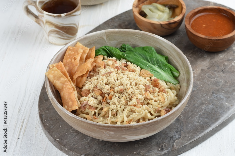 Cwie Mie is authentic noodles dish from Malang, Indonesia. Noodle served with minced chicken, fried shallot and fried dumpling or cracker Cwie Mie is authentic noodles dish from Malang, Indonesia. Noodle served with minced chicken, fried shallot and fried dumpling or cracker