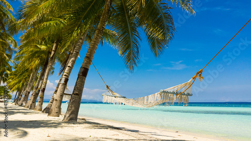 Tropical landscape: beautiful beach with hammock and tropical sea. Panglao island, Bohol, Philippines. Summer and travel vacation concept. photo