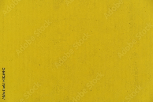Nice concrete background toned yellow, natural textured surface - Concrete yellow colorful wall surface texture - Grunge bright illuminating color background with aging effect - Color of the year