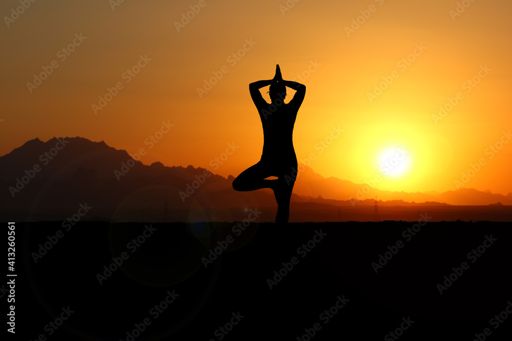 Frau meditiert im Sonnenuntergang