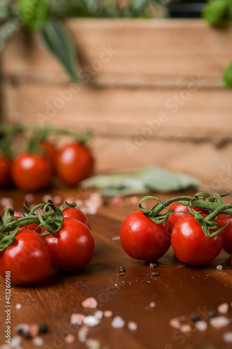 Red cherry tomatoes in a food photography scene with wood basket and details in background