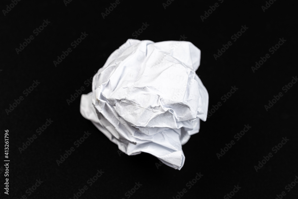 A crumpled paper ball in a black background A crumpled paper ball in a black background
