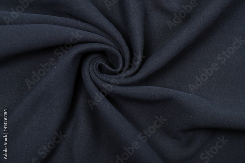 Pleats on fabric, knitted material of dark blue color, folds