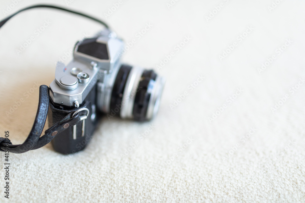 Antique film camera on white blanket on a bed by the window. Stylish hobby time. Antique film camera on white blanket on a bed by the window. Stylish hobby time.