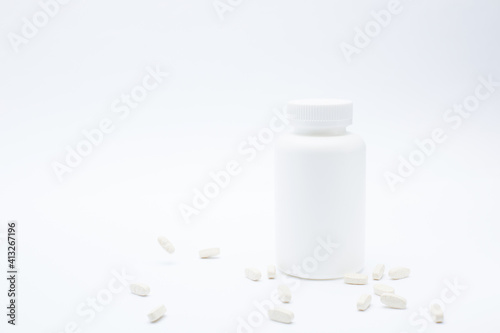 White plastic bottle with pills in gravity isolated on white background.