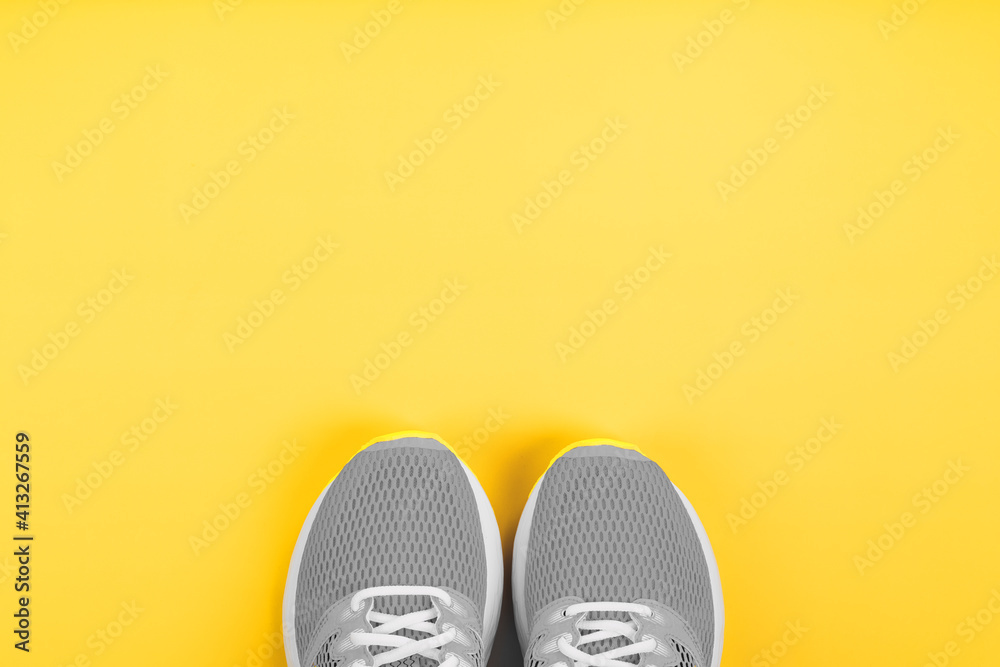 Sports gray sneakers on a yellow background - sport concept, free space.