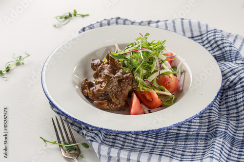 Balsamic Braised Beef slow cooked beef roast with fresh tomatoes on the table