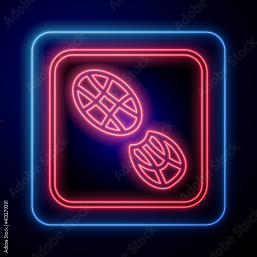 Glowing neon Human footprints shoes icon isolated on black background. Shoes sole. Vector.