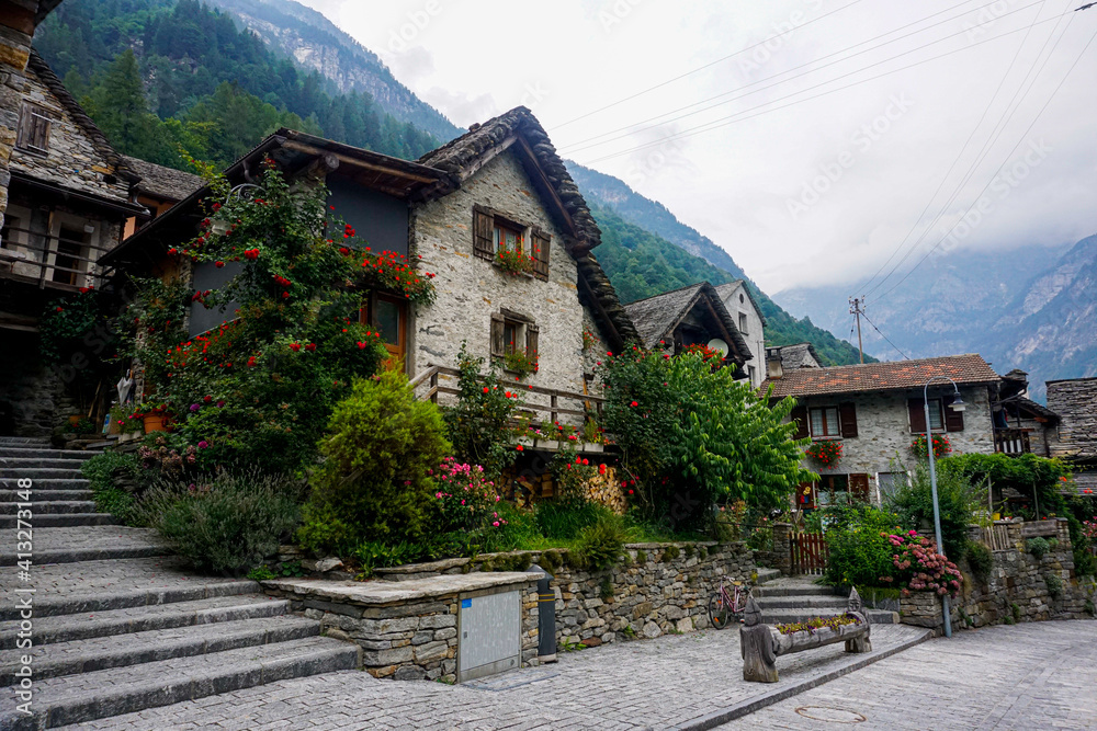 Traditional rustic stone house with lots of flowers in Sonogno, Switzerland
