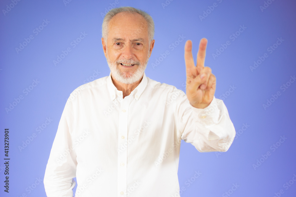 Senior grey-haired man wearing casual shirt standing over isolated violet background smiling with happy face looking at the camera doing victory sign with fingers. Number two. Senior grey-haired man wearing casual shirt standing over isolated violet background smiling with happy face looking at the camera doing victory sign with fingers. Number two.
