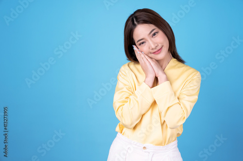 Beautiful Asian woman shows sleeping postures, Isolated on a blue background.