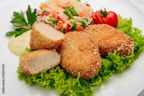 Chicken cutlets in batter with risotto and vegetables