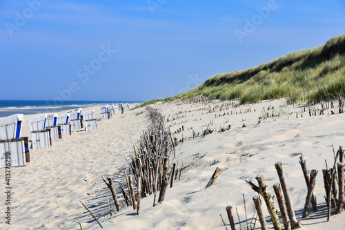 Idyllic dune landscape on the holiday island of Sylt with beach chairs and the North Sea at low tide