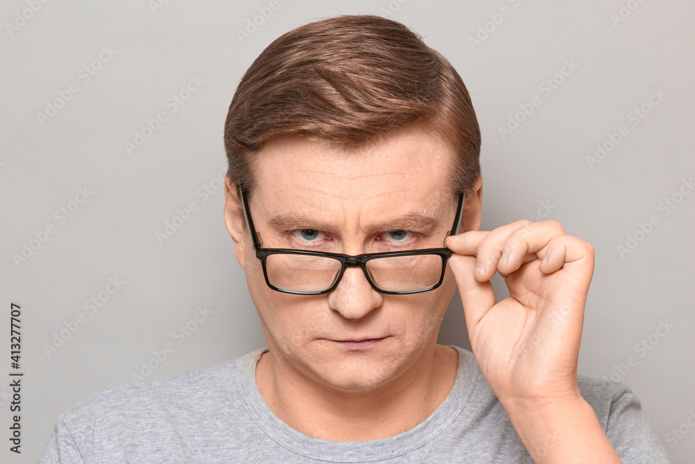 Portrait of blond mature man looking attentively over his glasses Portrait of blond mature man looking attentively over his glasses