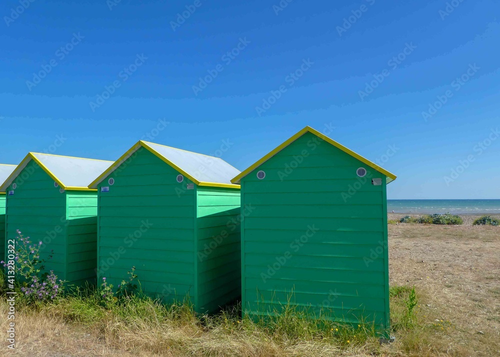 bright green beach huts on the seashore