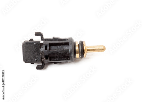 Black coolant temperature sensor on a white background with yellow metal elements. The engine control unit corrective composition of the air-fuel mixture, the engine idle speed, the ignition timing.