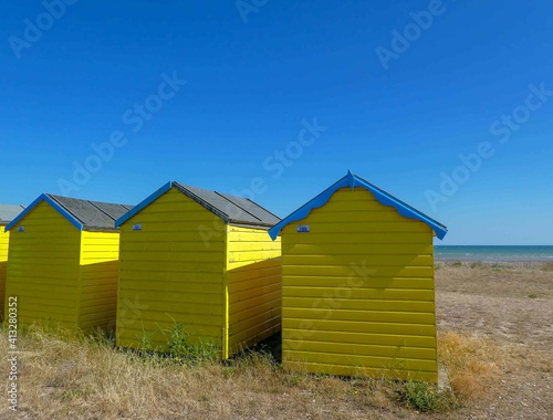 bright yellow beach huts on the seashore © Penny