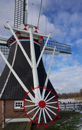 Selected parts of an ancient dutch windmill against a blue sky with some clouds photo