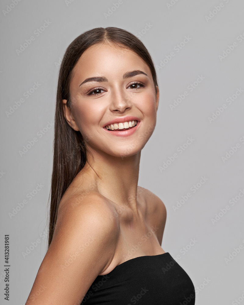 Young beautiful female model close-up studio beauty portrait. Girl with natural make-up and long brunette straight hair. Happy smiling woman looking at you Young beautiful female model close-up studio beauty portrait. Girl with natural make-up and long brunette straight hair. Happy smiling woman looking at you