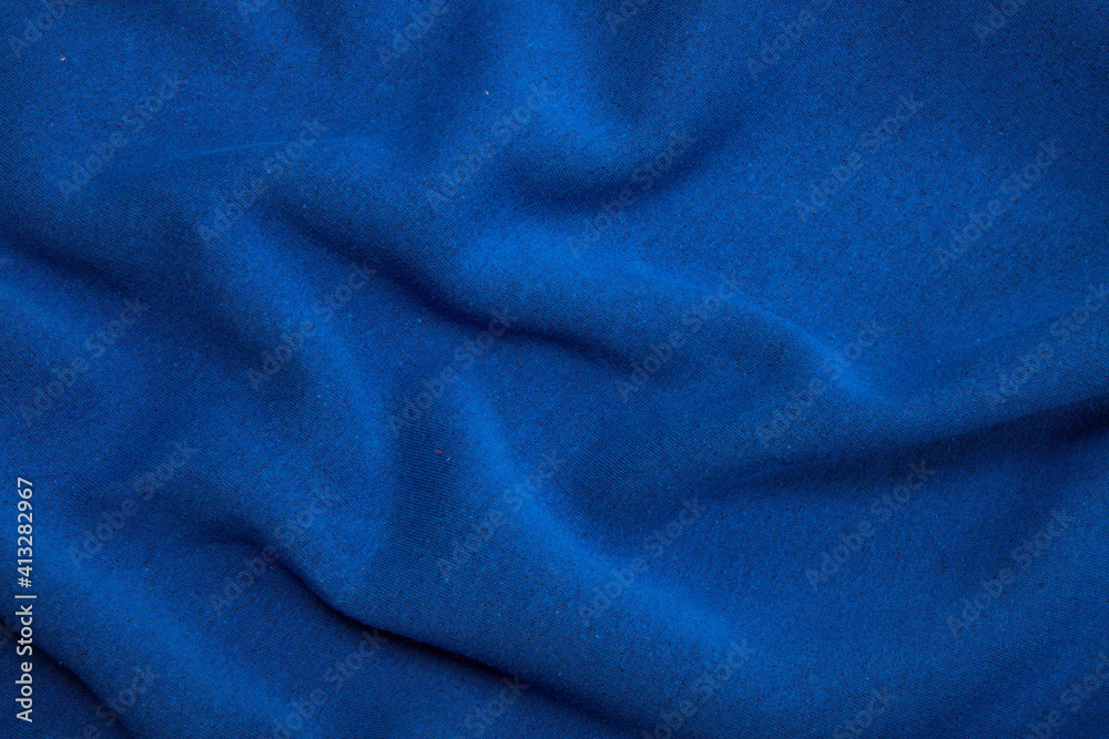 Pleats on fabric, knitted material of bright blue color, folds Pleats on fabric, knitted material of bright blue color, folds