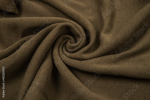 Pleats on fabric, knitted material of khaki color, folds