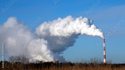 A cloud of smoke soars from an industrial chimney