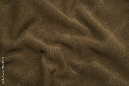 Pleats on fabric, knitted material of khaki color, folds