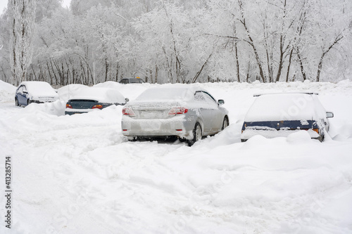 Cars covered by snow, parking in the courtyard of an apartment building after a snowstorm