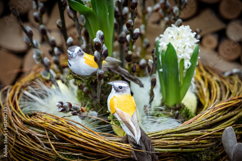 Easter bouquet composition with colorful eggs in nest on wooden background. Angement flower eco with copy space photo